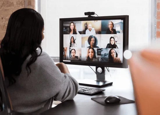 ノートパソコンで一般英会話レッスンを受ける若い女性。